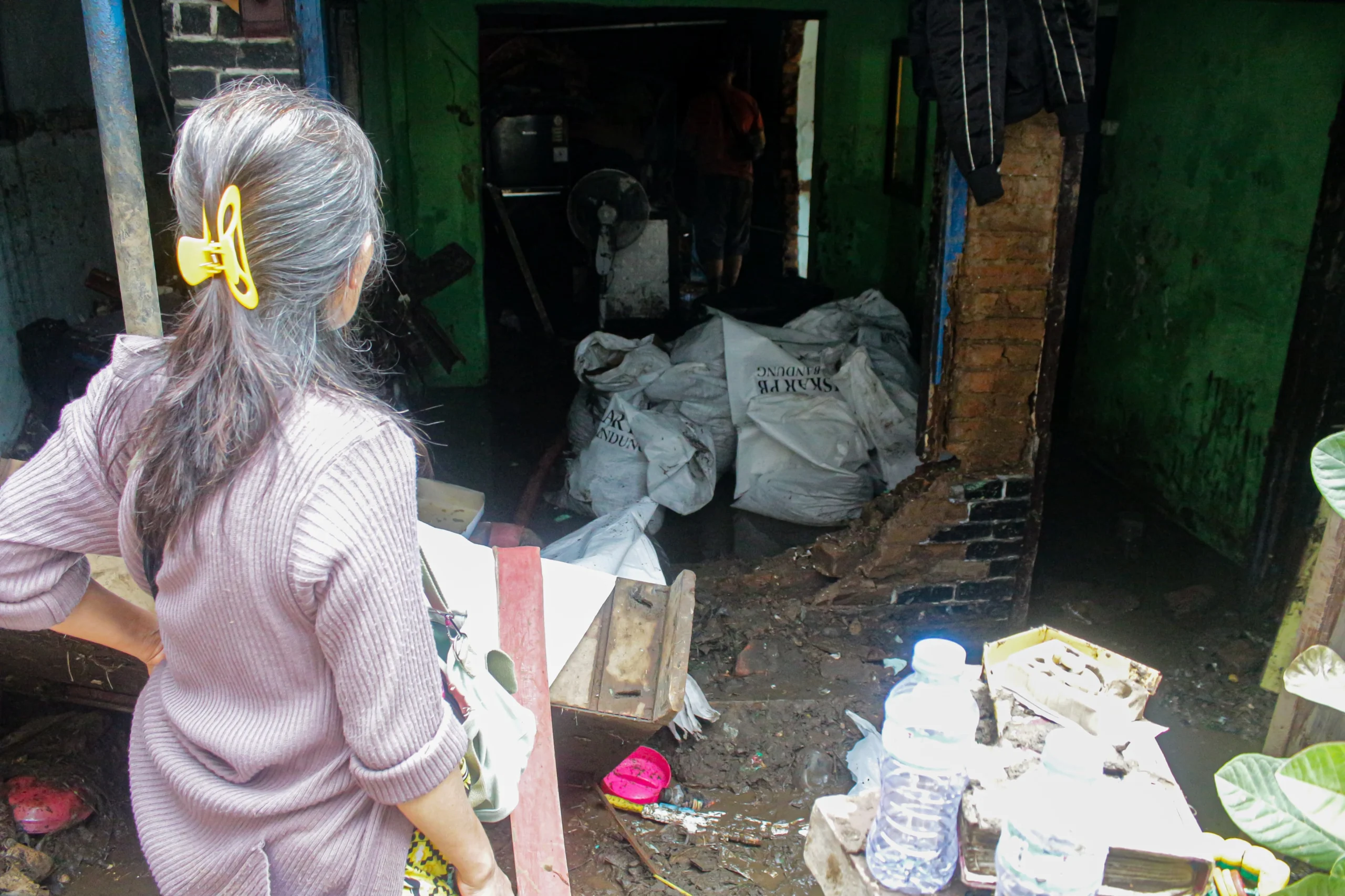 Salah satu rumah warga jebol dikarenakan debit air tinggi serta arus deras saat Sungai Cikapundung meluap di kawasan Gang Apandi, Kelurahan Braga, Kota Bandung, Jumat (12/1).