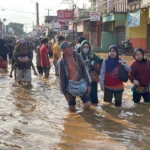 Masyarakat sedang menempuh banjir di Dayeuhkolot, Kabupaten Bandung.