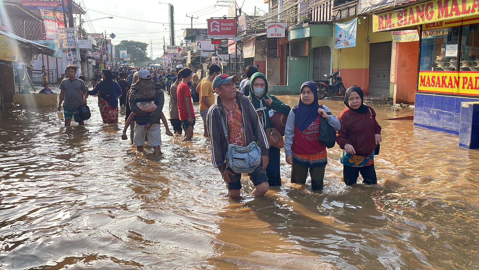 Masyarakat sedang menempuh banjir di Dayeuhkolot, Kabupaten Bandung.