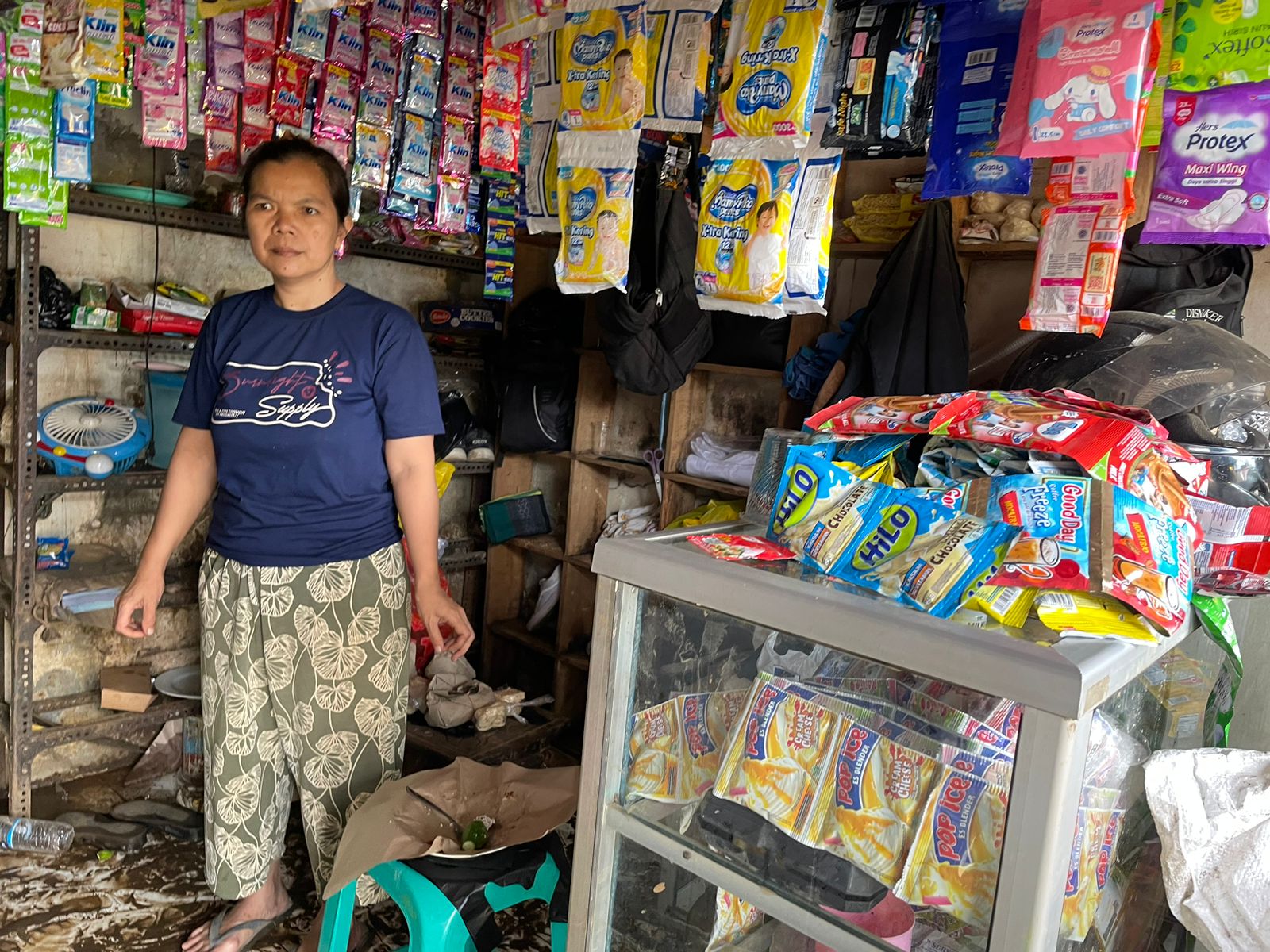 Yani Maryani (49) salah satu warga saat sedang membersihkan dagangannya akibat banjir bandang yang melanda Kampung Lamajang Peuntas, Dayeuhkolot, Kabupaten Bandung akibat jebolnya tanggul Sungai Cigede. Foto Agi Jabar Ekspres