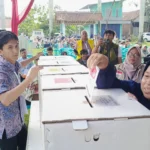 Warga memasukkan spesimen surat suara ke dalam kotak suara usai melakukan pencoblosan di bilik suara di TPS 12 Neglasari dalam acara simulasi pungut hitung yang digelar KPU Kota Banjar, Rabu 31 Januari 2024.