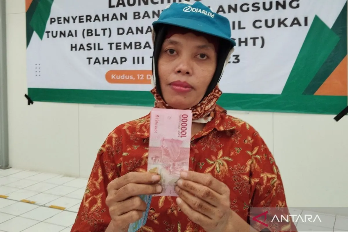 seorang pekerja menunjukkan uang dari program bantuan langsung tunai (BLT) untuk buruh rokok.
