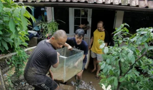 Masyarakat terdambak banjir memindahkan perabot rumah tangga yang masih dapat digunakan di Gang Apandi, Kelurahan Braga, Kota Bandung, Jum'at(12/1). (Pandu Muslim/Jabar Ekspres)