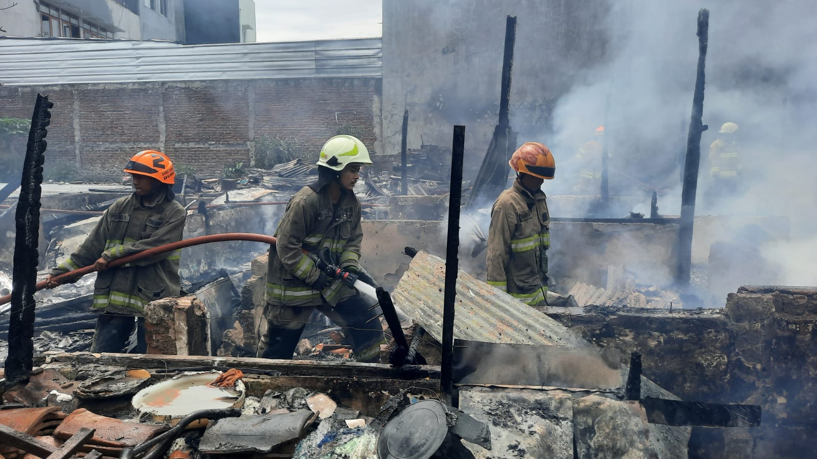 Petugas Diskar PB Kota Bandung tengah memadamkan sisa api kebakaran di Gang Irit, Jalan Ahmad Yani, pada Rabu (17/1).