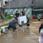 Warga Gang Apandi, Kelurahan Braga saat menyelamatkan barang berharga dari banjir bandang akibat meluapnya Sungai Cikapundung, Kamis (11/1) sore.