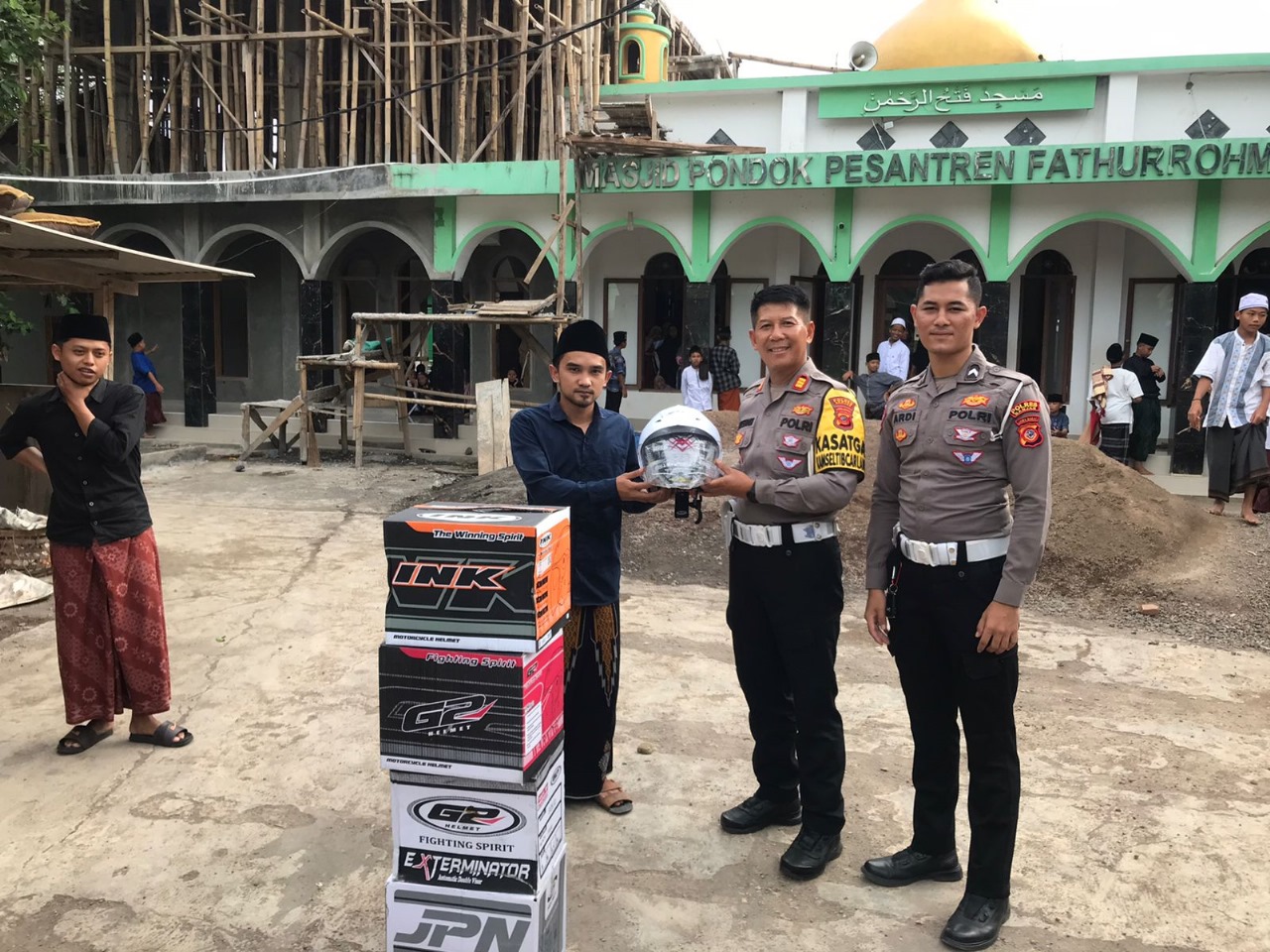 Kasat Lantas Polres Banjar AKP Otong Rustandi memberikan helm kepada santri di Ponpes Fathurrohman Desa Binangun Kecamatan Pataruman Kota Banjar, Jumat 2 Februari 2024. (Cecep Herdi/Jabar Ekspres)