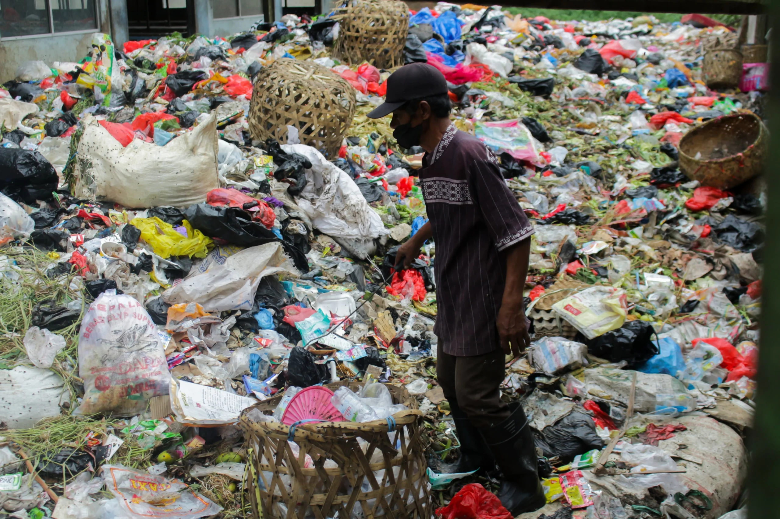 Ilustrasi: Seorang pria tengah berada di atas tumpukan sampah Pasar Sehat Cileunyi, Kabupaten Bandung. (Pandu Muslim/Jabar Ekspres)