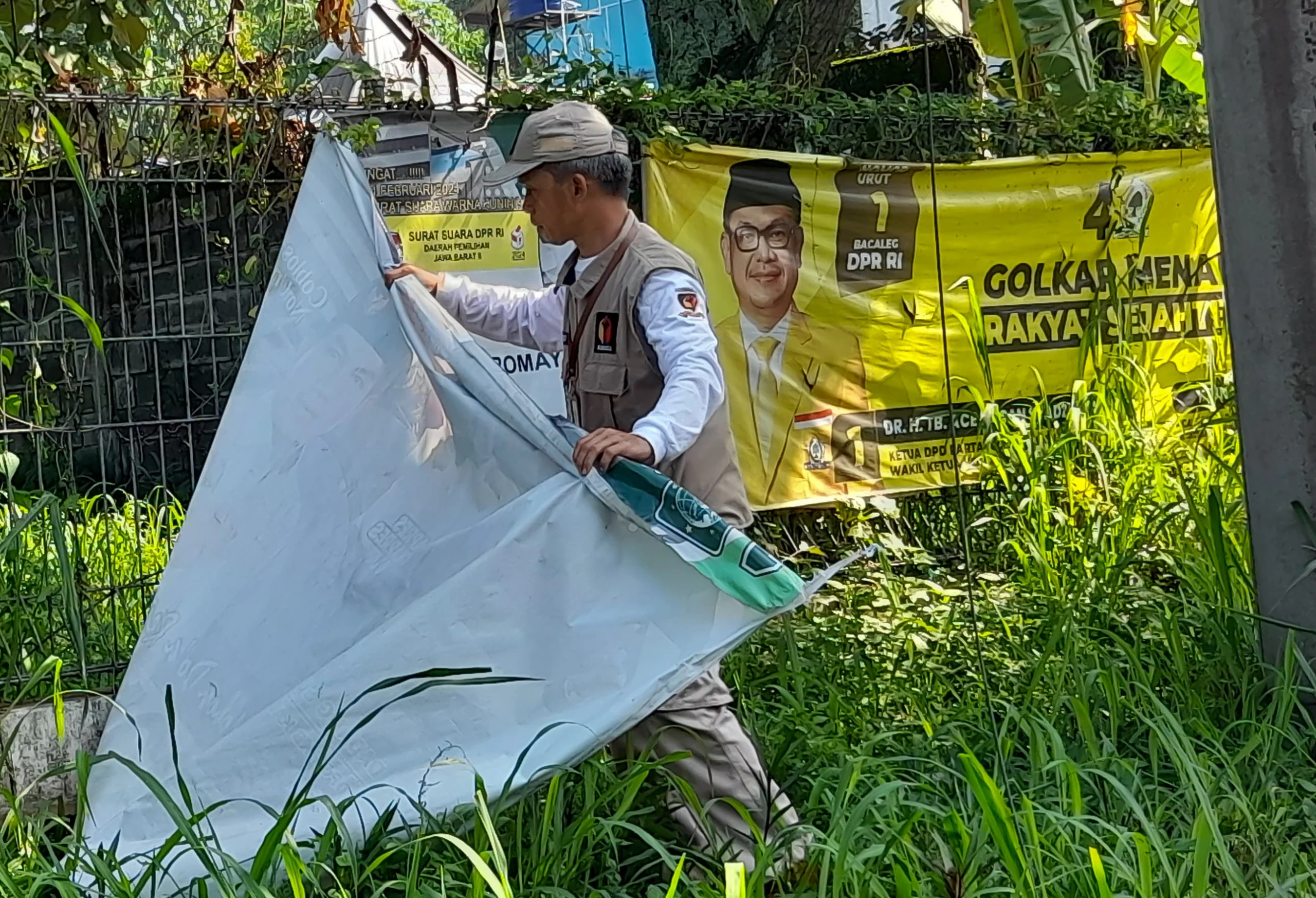 Petugas Bawaslu beserta Satpol PP mencopot APK Parpol yang masih terpasang saat masa tenang Pemilu 2024 di kawasan Jalan Percobaan, Kecamatan Cileunyi, Kabupaten Bandung.