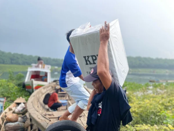 Petugas penyelenggara Pemilu di Bandung Barat distribusikan logistik ke ujung wilayah KBB menggunakan perahu. Selasa (13/2). Foto Jabarekspres/wit