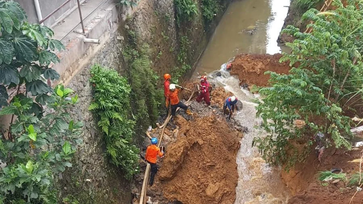 Sejumlah Petugas BPBD Kota Bogor saat melakukan evakuasi korban di lokasi longsor TPT di Muarasari, Kecamatan Bogor Selatan, Minggu (18/2).
