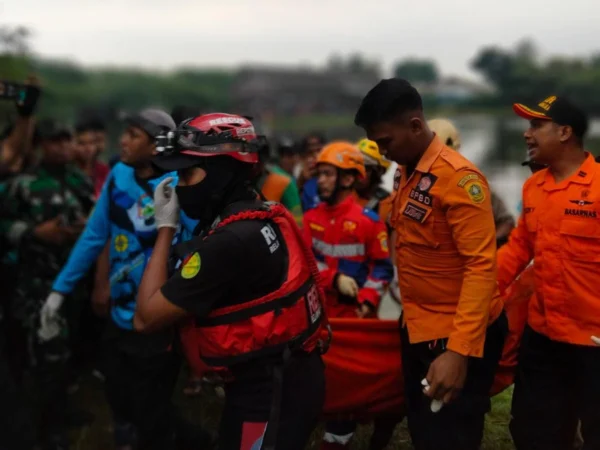 Petugas gabungan sedang mengevakuasi Mario (13), bocah yang tenggelam saat berenang di Setu Rawa Sudat, Sabtu (24/2).