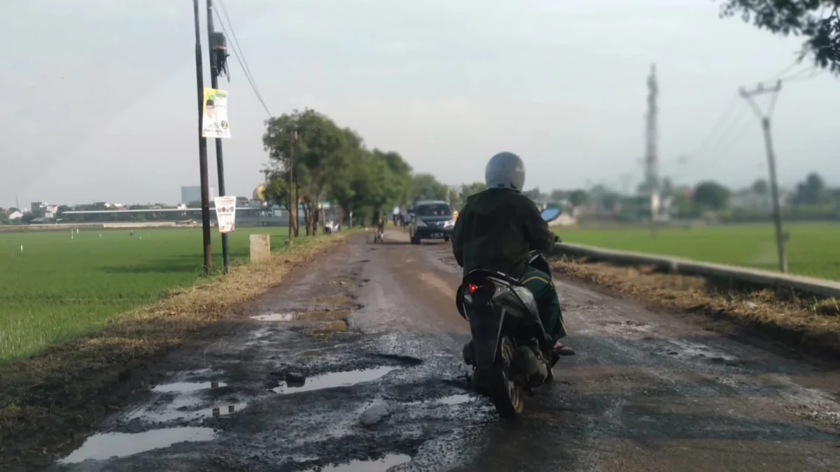 Kondisi jalan rusak dan banyak lubang di wilayah Desa Cibiru Hilir, Kecamatan Cileunyi, Kabupaten Bandung.