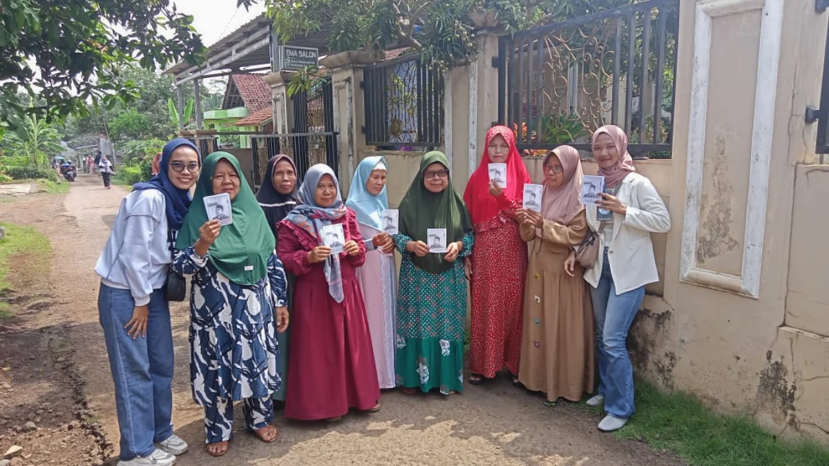 Salah satu tim milenial Bambang Hidayah Center (BHC) membagikan selebaran profil Bambang Hidayah kepada emak-emak di salah satu desa di Kota Banjar, Rabu 28 Februari 2024.