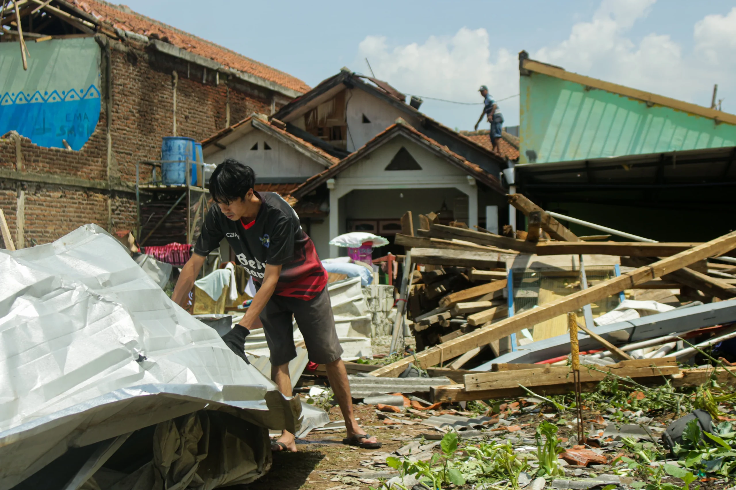 Warga membersihkan sisa puing bangunan yang diterjang Tornado di Desa Sukadana, Kecamatan Cimanggung, Kabupaten Sumedang. (Pandu Muslim/Jabar Ekspres)