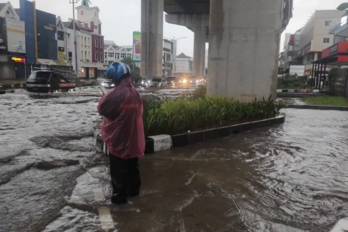 Dok. Warga melintas di jalan yang terendam banjir (Antara)