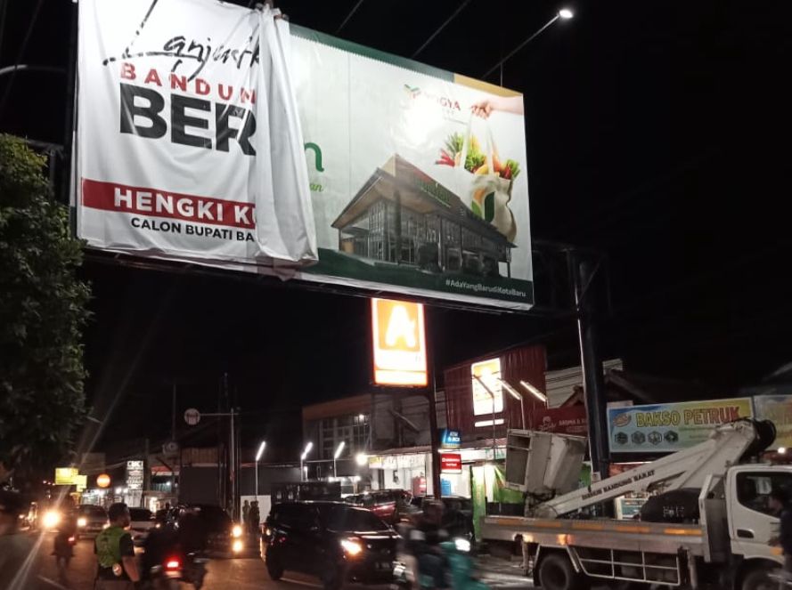 Petugas Satpol PP KBB saat menertibkan baliho mantan Bupati Bandung Barat, Hengky Kurniawan yang terpasang di ppan reklame di ruas Jalan Raya Cimareme, KBB.