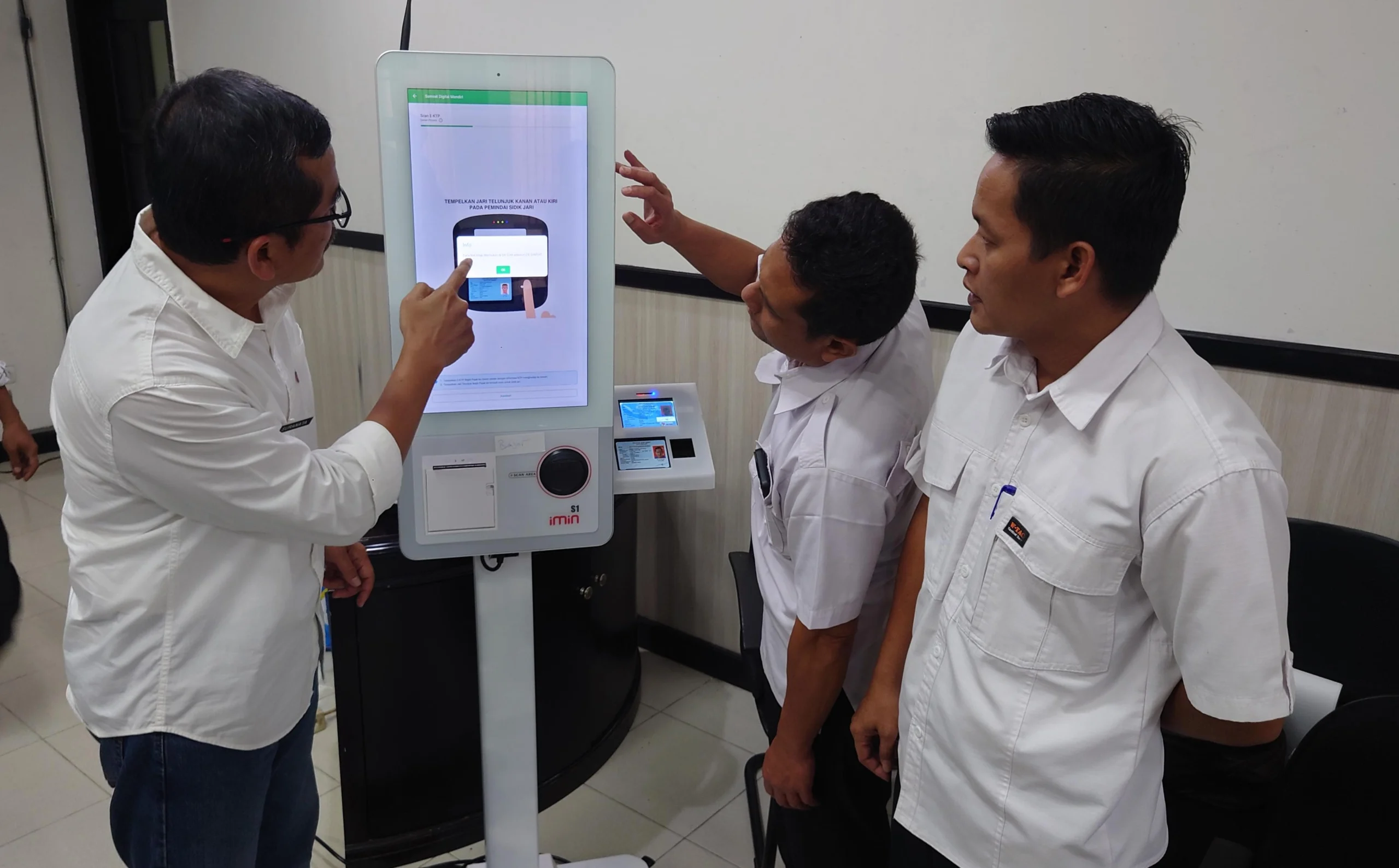 Kepala P3DW Kota Banjar, Benny Suranata (kiri) menunjukkan cara kerja mesin Anjungan Digital Mandiri (ADM) atau Samsat Digital kepada salah satu pejabat ASN di Kota Banjar, Rabu 20 Maret 2024.