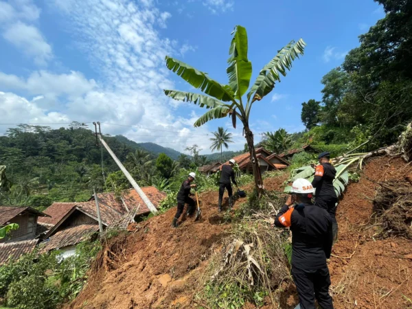 Petugas gabungan dari Korps Brimob tengah mengevakuasi material longsor di Kampung Gintung. Senin (25/3). Foto Jabarekspres
