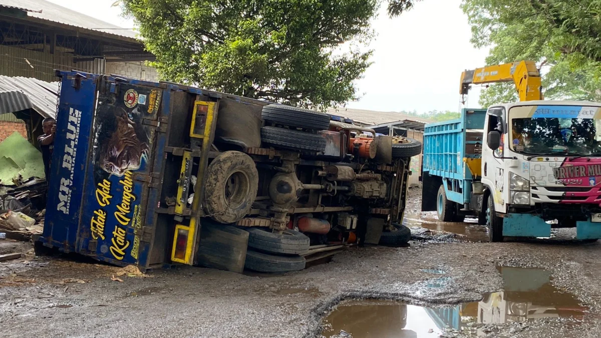 Truk terguling di Jalan Raya Babakan, Kecamatan Cikembar, Kabupaten Sukabumi, akibat jalan rusak, Rabu (27/3).