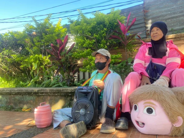 Sepasang suami isteri yang tengah beristirahat sehabis keliling menjadi badut. Riki Achmad/Jabar Ekspres