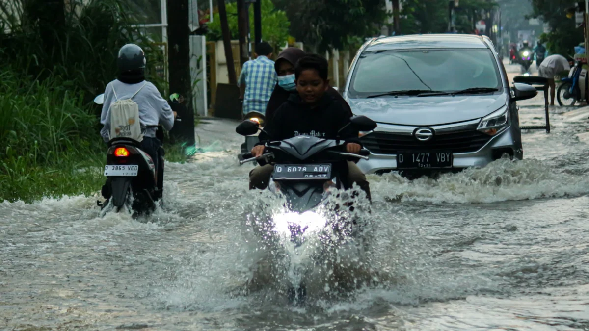 Ilustrasi: Sejumlah warga Kota Bandung sedang menerabas banjir yang menggenangi jalan. (Pandu Muslim/Jabar Ekspres)