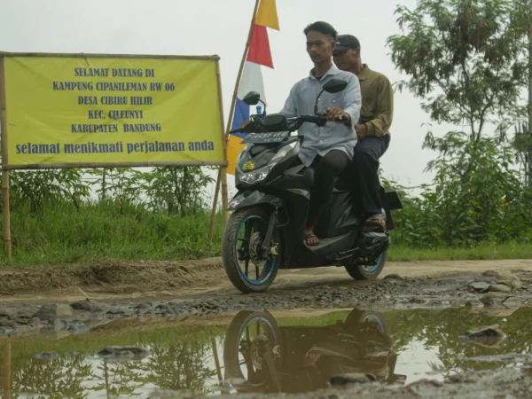 Pengguna motor melewati jalan menuju Stasiun Tegalluar Kereta Cepat Whoosh di Desa Cibiru Hilir, Kecamatan Cileunyi, Kabupaten Bandung, Minggu(7/4). Pandu Muslim/Jabar Ekspres