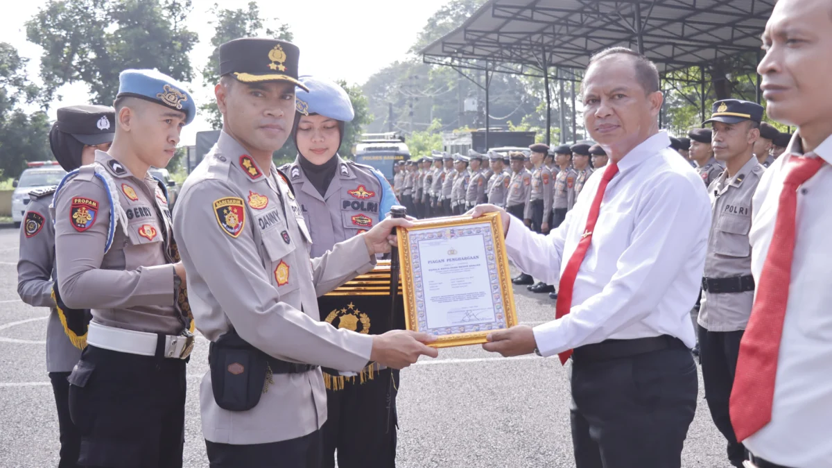 Kapolres Banjar AKBP Danny Yulianto memberikan penghargaan kepada satu dari 18 anggotanya yang berprestasi, di halaman Mapolres Banjar, Senin 22 April 2024. (Cecep Herdi/Jabar Ekspres)