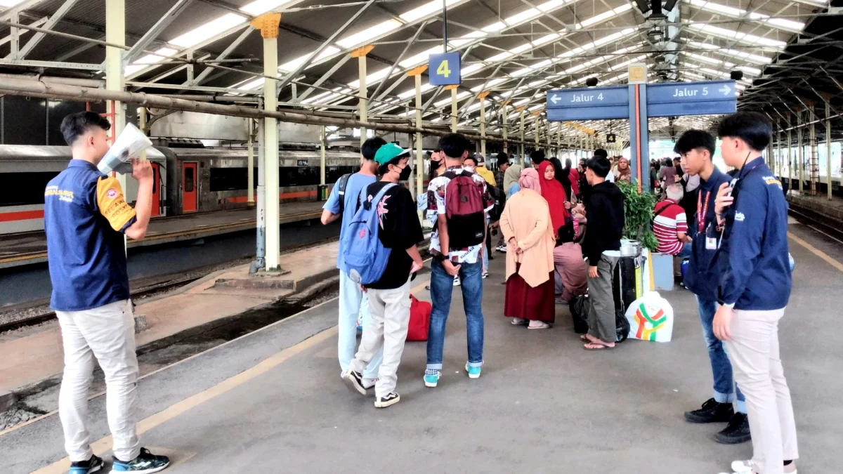 Anggota Komunitas Edan Sepur turut menertibkan penumpang di Stasiun Bandung, Senin (8/4)