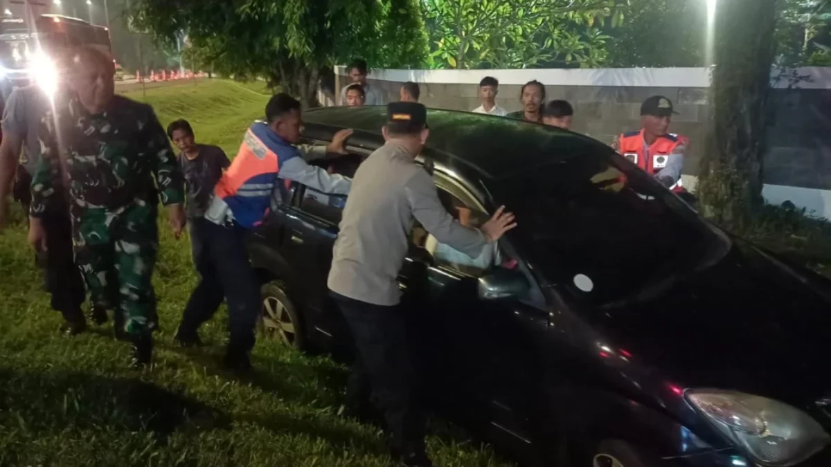 Petugas gabungan saat mengevakuasi Mobil Avanza hitam dari dalam parit di Jalan Jalan Raya Cilameri-Subang, Kabupaten Subang, Minggu (8/4).