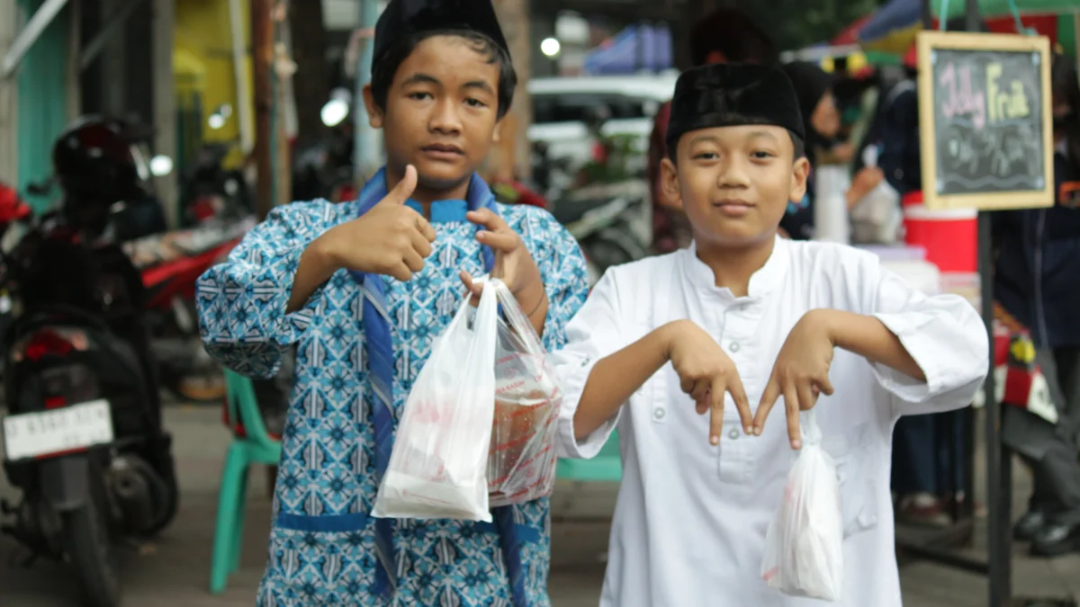 Ilustrasi: Dua anak-anak (bocil) riang usai berhasil membeli makanan saat berburu menu takjil Ramadan di area Alun-Alun Ujungberung, Kota Bandung.
