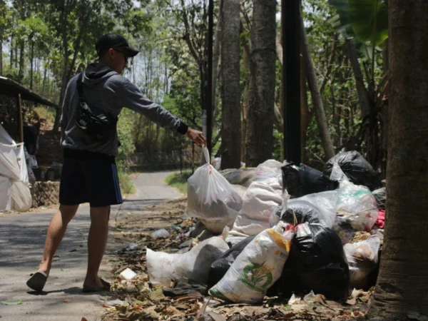 Ilustrasi: Seorang warga Cimahi sedang membuang sampah sembarangan.