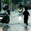 Meluapnya saluran air mengakibatkan jalanan tergenang banjir di kawasan Cibiru Hilir, Cileunyi, Kabupaten Bandung. (Pandu Muslim/Jabar Ekspres)