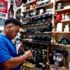 Yosep Tobing sedang membersihkan koleksi kamera jadul miliknya di Pasar Antik Cikapundung.