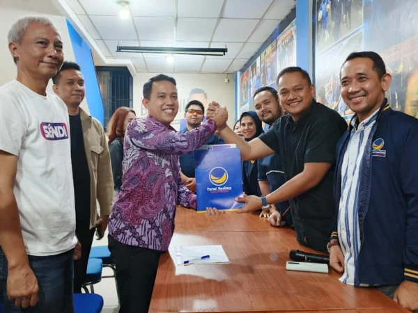 Sendi Fardiansyah saat menyerahkan formulir pendaftaran penjaringan Bacawalkot Bogor kepada Ketua DPD Partai Nasdem, Benninu Argobie. (Yudha Prananda / Jabar Ekspres)