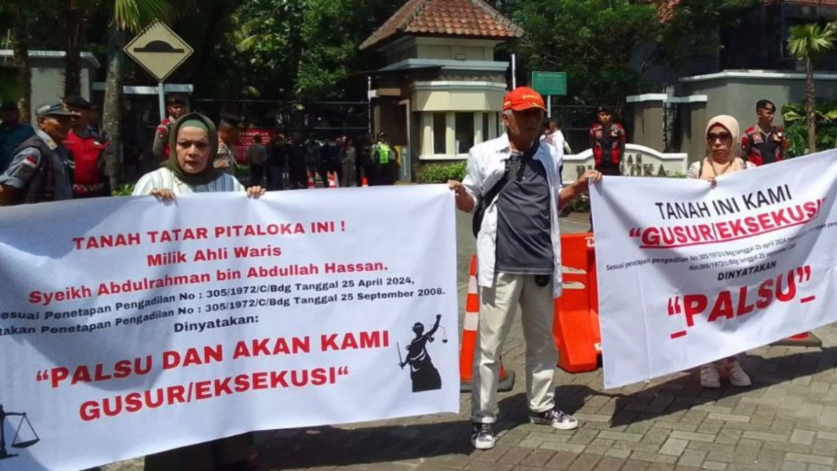 Sejumlah ahli waris bentangkan spanduk protes di depan gerbang Tatar Pitaloka Kota Baru Parahyangan, Kabupaten Bandung Barat. Senin (6/5). Foto Jabar Ekspres