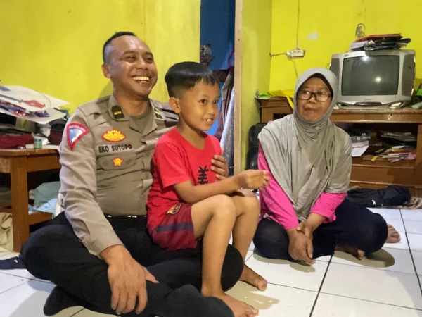 Ilham Ramadhan (8) bersama ibunya, Kokom Komala (47), saat beberapa polisi mengunjungi rumah mereka di Desa Bandasari, Kecamatan Cangkuang, Kabupaten Bandung. Foto Agi Jabar Ekspres