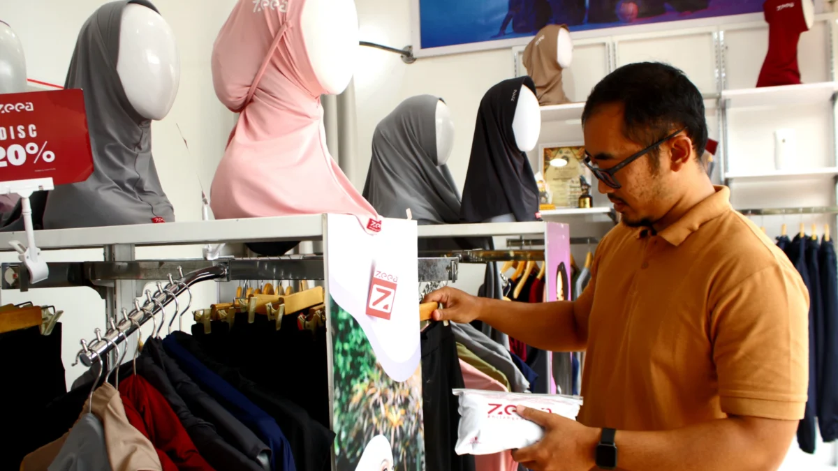 PELUANG : Diky saat merapikan sejumlah produk busana sport muslimah miliknya di Gerai yang berada di Kota Cimahi, Sabtu (1/6) (Hendrik Muchlison)