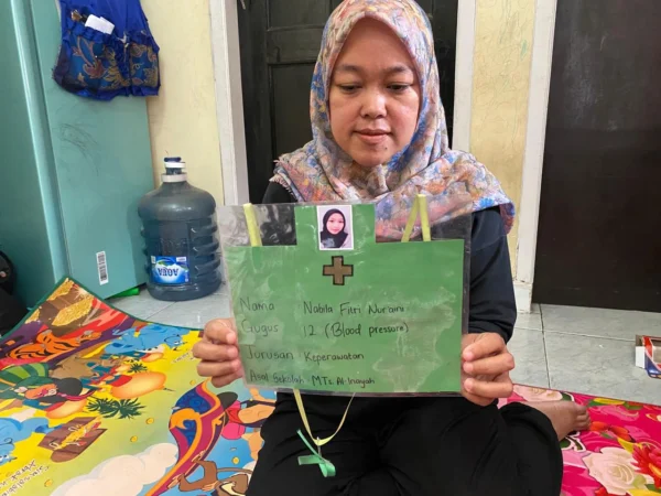 Siti, sang ibu saat memperlihatkan foto serta biodata anakanya, Nabila yang diduga menjadi korban aksi bullying di Bandung Barat. Senin (10/6). Dok Jabar Ekspres