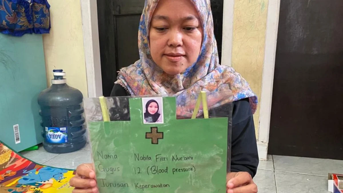 Siti, sang ibu saat memperlihatkan foto serta biodata putrinya yakni Nabila yang diduga menjadi korban aksi perundungan di Bandung Barat. Dok istimewa
