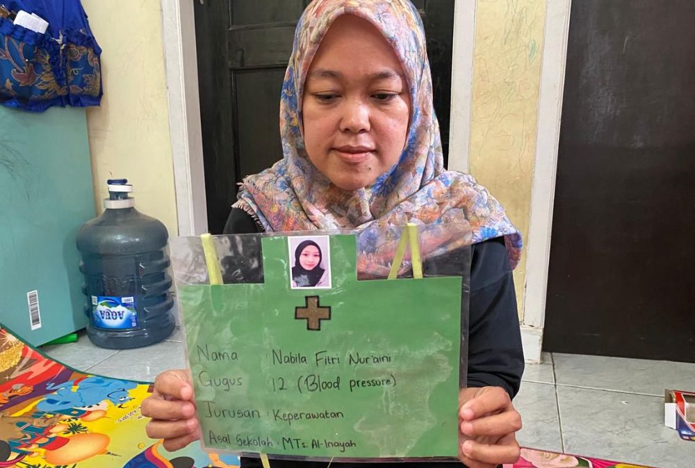 Siti, sang ibu saat memperlihatkan foto serta biodata putrinya yakni Nabila yang diduga menjadi korban aksi perundungan di Bandung Barat. Dok istimewa
