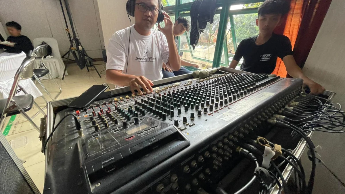 Aras (36), pemilik Sadaraya Sound, sebuah vendor penyedia jasa sound system saat menyelaraskan audio mixernya. Foto Agi Jabar Ekspres