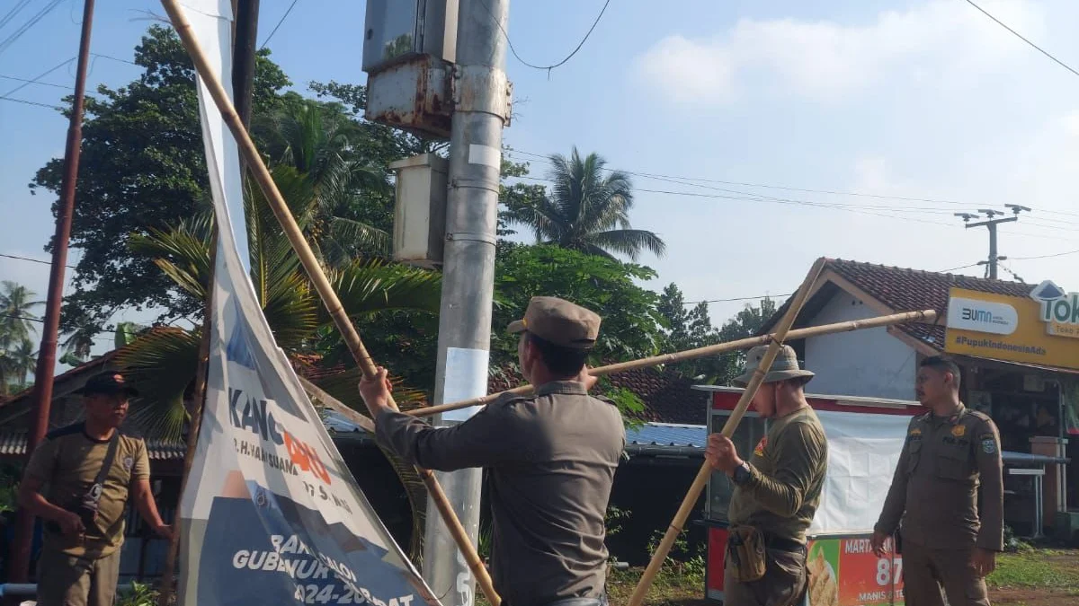 Anggota Satpol PP Kota Banjar menertibkan papan baliho yang melanggar Perda Kota Banjar nomor 6 tahun 2022, Kamis 27 Juni 2024. (Cecep Herdi/Jabar Ekspres)