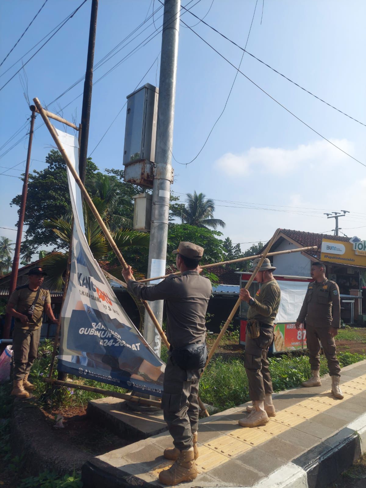 Anggota Satpol PP Kota Banjar menertibkan papan baliho yang melanggar Perda Kota Banjar nomor 6 tahun 2022, Kamis 27 Juni 2024. (Cecep Herdi/Jabar Ekspres)