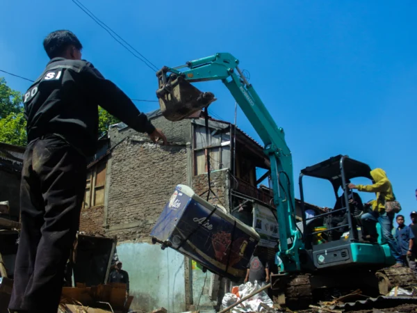 Ekskavator turut dikerahkan untuk membersihkan puing rumah yang rusak akibat pecahnya pipa milik PDAM Tirnawening di Cibangkong, Kota Bandung. (Pandu Muslim Jabar Ekspres)