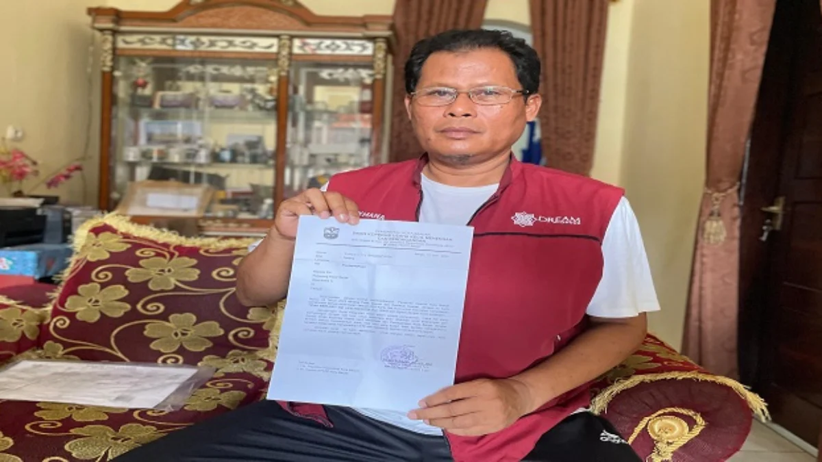 Kepala Paguyuban Keluarga Besar Pedagang Pasar Banjar (KBPPB) Aa Sukmana menunjukkan surat edaran dari Dinas KUKMP Kota Banjar, terkait hak huni kios kelas 1. (Cecep Herdi/Jabar Ekspres)
