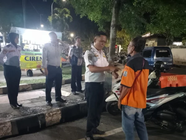 Pegawai dari Dinas Perhubungan Kota Banjar saat mengimbau salah satu juri parkir yang menunggak setoran retribusi di salah satu ruas jalan di Kota Banjar, Senin 10 Juni 2024 malam. (Cecep Herdi/Jabar Ekspres)