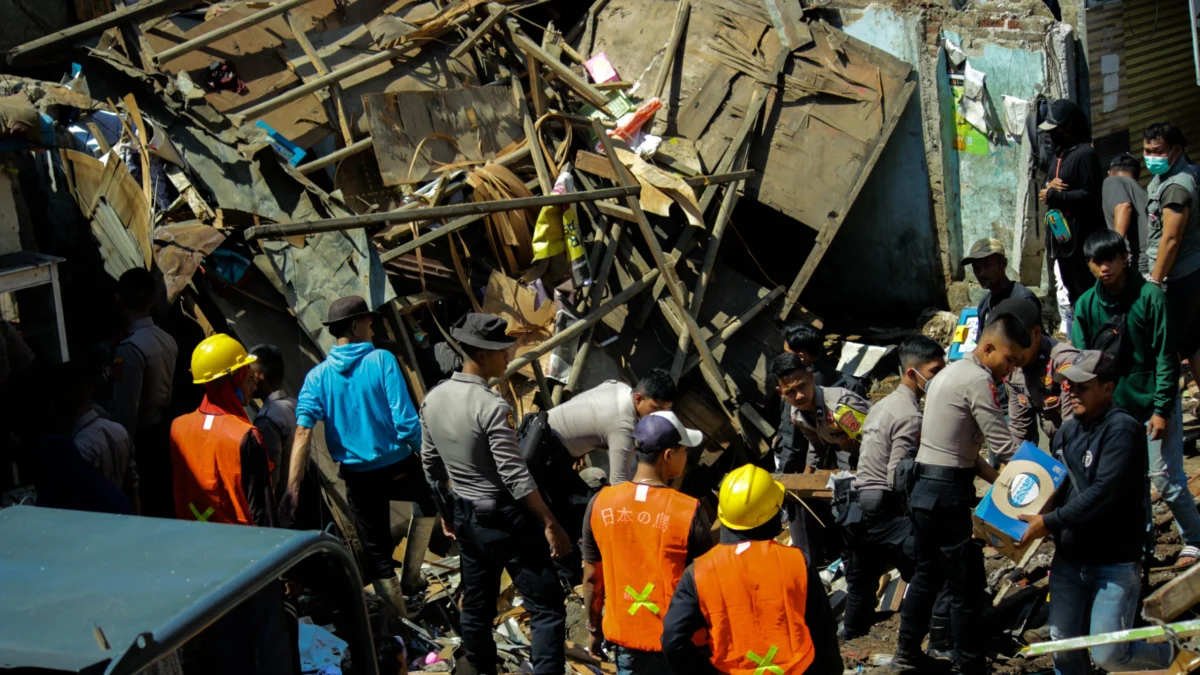 Masyarakat, kepolisian hingga petugas PU turut membersihkan puing rumah yang rusak akibat pecahnya pipa milik PDAM Tirnawening di Cibangkong, Kota Bandung, Kamis(6/6/2024). (Pandu Muslim Jabar Ekspres)