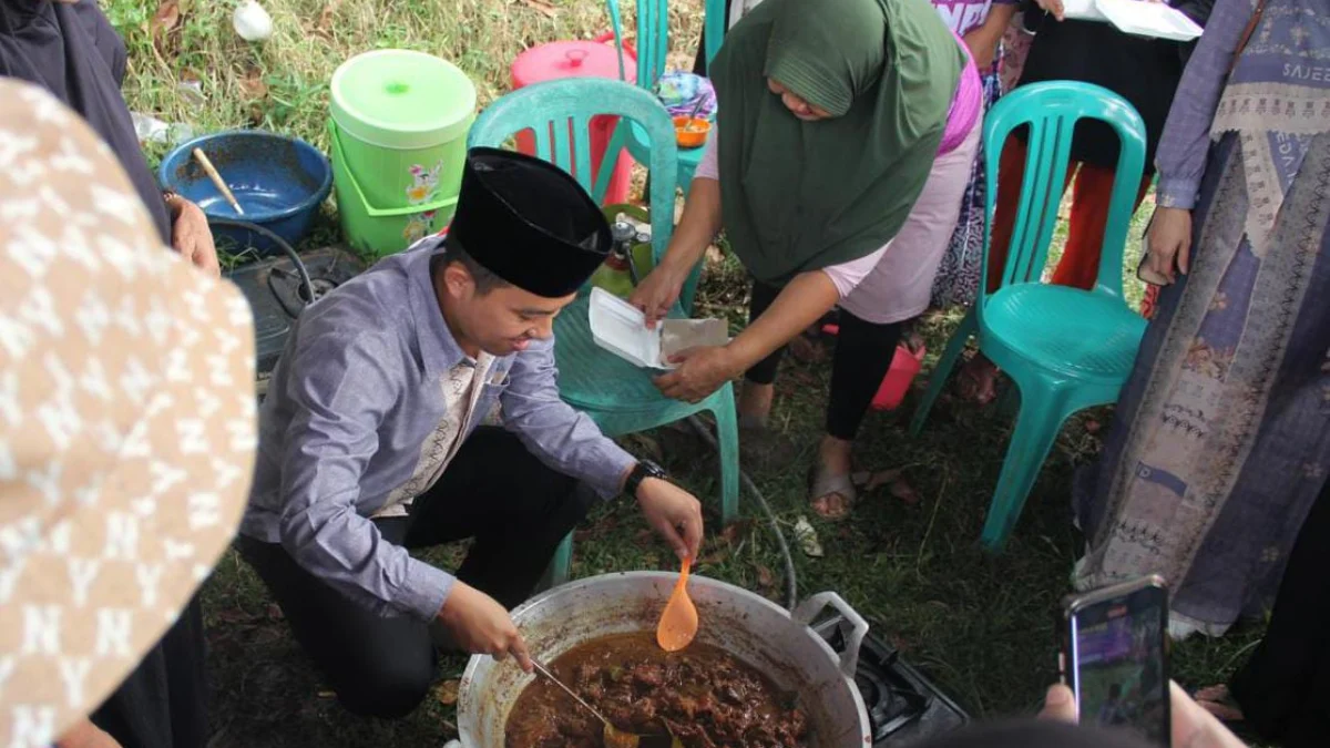 Bacawalkot Bogor, Sendi Fardiansyah saat menyajikan hidangan daging kurban yang sudah dimasak kepada warga Kelurahan Katulampa, Kota Bogor. (Yudha Prananda / Istimewa)