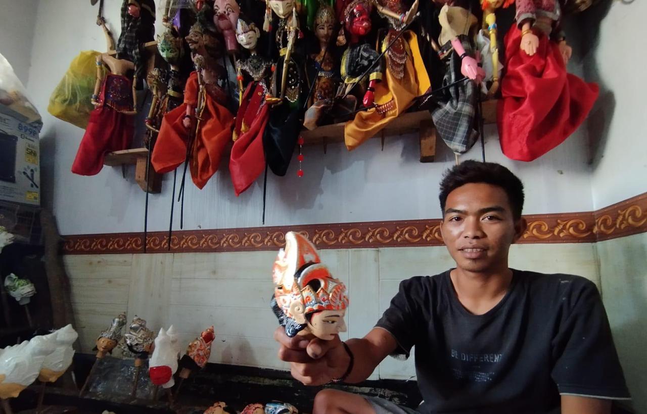 Risnandar (32) seniman muda wayang golek saat mengukir wayang pesanannya di kediamannya di Desa Cibiru Wetan, Cileunyi, Kabupaten Bandung. Foto Agi Jabar Ekspres