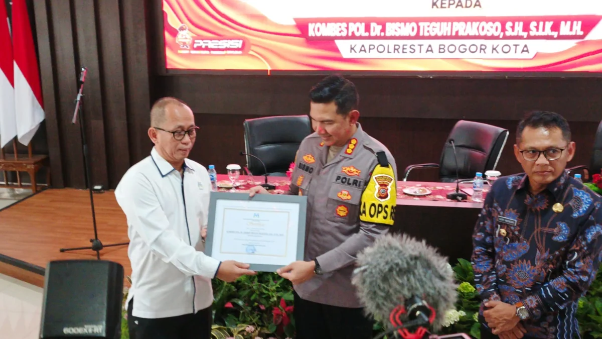 Deputi Perlindungan Anak Kementerian PPPA RI, Nahar saat memberikan penghargaan kepada Kapolresta Bogor Kota, Kombes Pol Bismo Teguh Prakoso, Selasa (9/7). (Yudha Prananda / Jabar Ekspres)